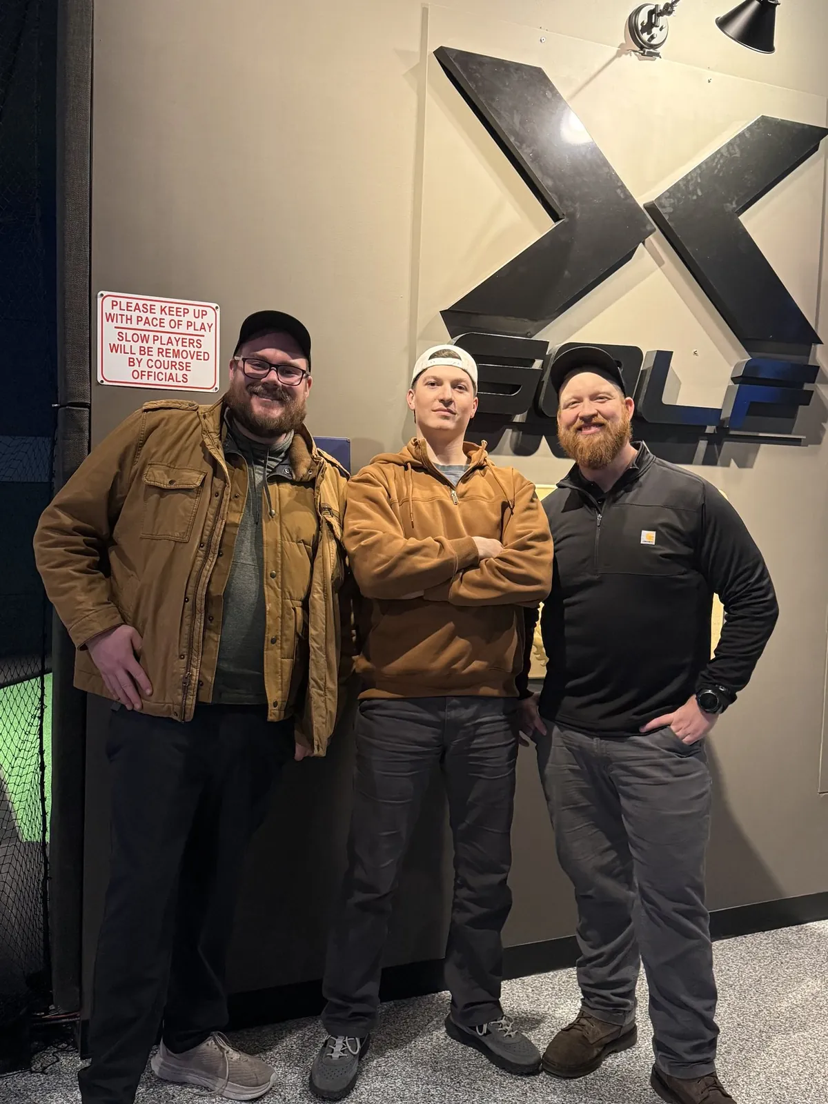 Nick, Chris Holmes, and a team member at X-Golf in Michigan celebrating two years of partnership