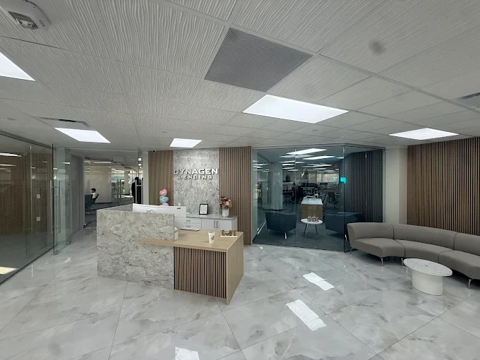 Dynagen Lending office reception with a marble desk, wood accents and glass meeting rooms