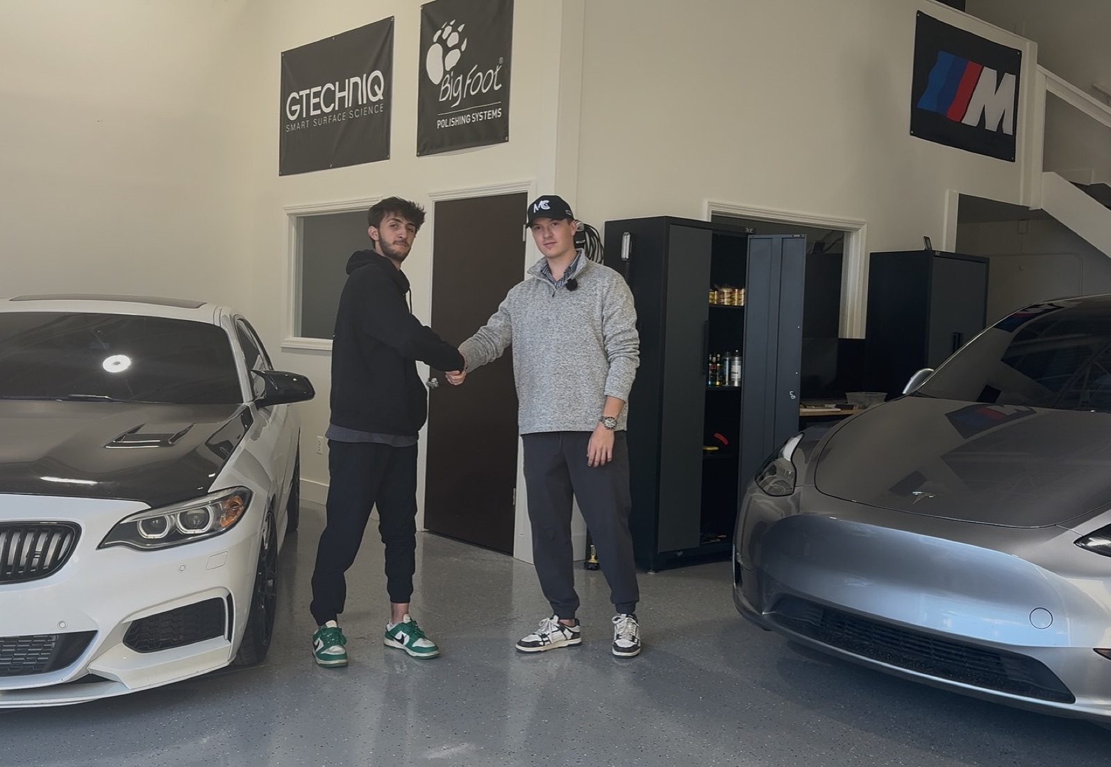 Nick and Alex from RPM Auto Lab shaking hands at the shop after signing a new engagement