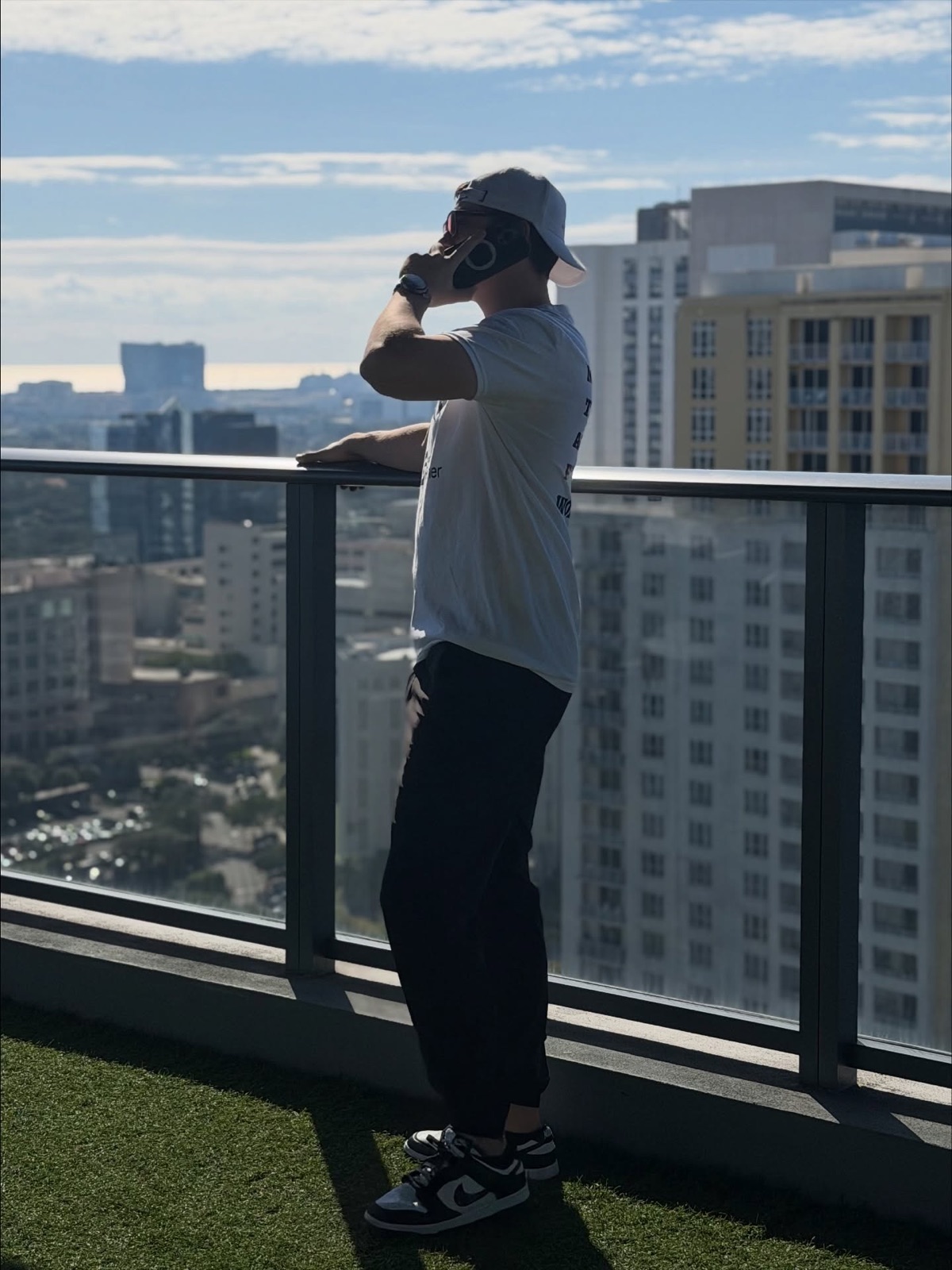 Nick looking out at a city skyline from a high-rise balcony